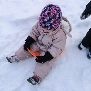 Aktuelles "Wintereinbruch" - Kind im Schnee auf einem Schneegleiter