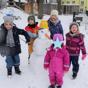 Aktuelles "Wintereinbruch" - Kinder Gruppenbild mit Schneemann