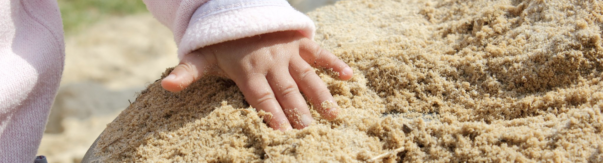Kleine Kinderhände spielen im Sand