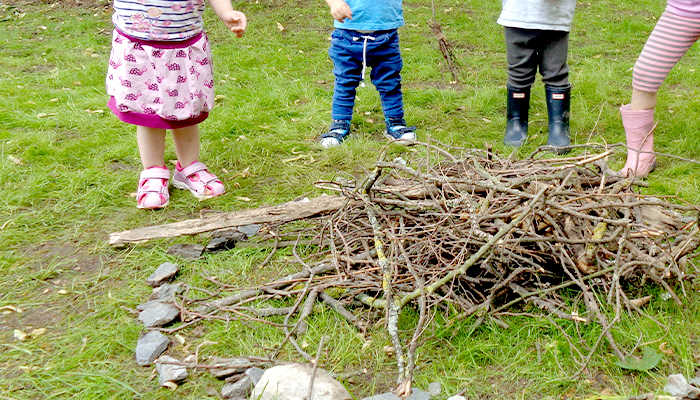 Kinder drauße von einem Holzhaufen