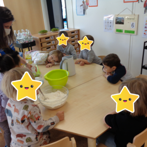 Die Kindergartenkinder backen einen Kuchen