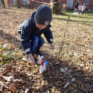 Junge findet Osternest im Garten