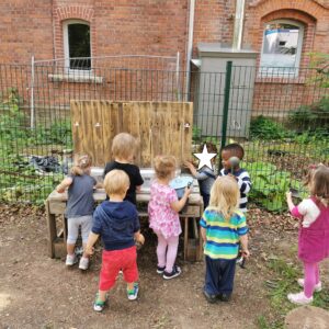 Die Kinder spielen an der Matschküche