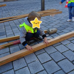 Kind baut eine Kugelbahn aus Holz