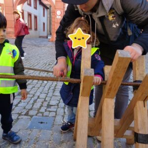 Kind sägt mit Hilfe eines Erwachsenen Holz