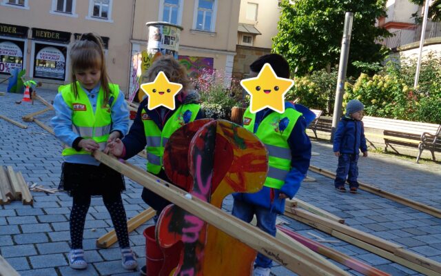 Kinder bauen an einer Kugelbahn aus Holz